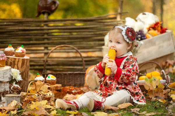 Genç kız haşlanmış mısır sonbahar Park'ta yemek — Stok fotoğraf