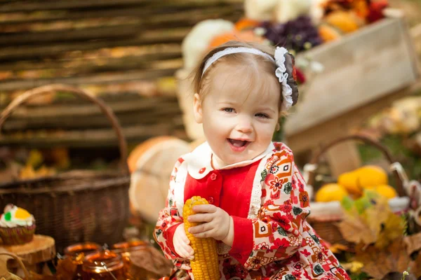 Jong meisje eten gekookte maïs in herfst park — Stockfoto