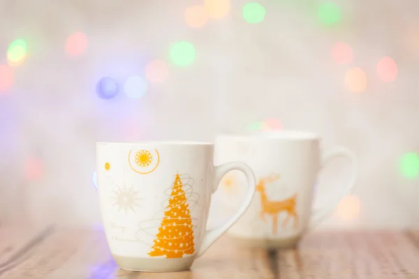 Dos tazas y luces de Navidad en el fondo — Foto de Stock