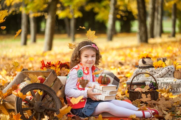 Kitap ve küçük kabak ile sonbahar parkta genç kız — Stok fotoğraf