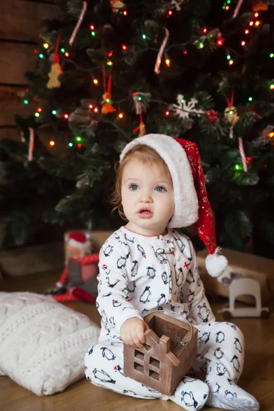 Cute girl in pajamas and christmas hat — Stock Photo, Image