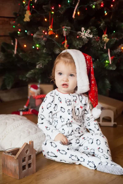 Aranyos lány pizsama és karácsonyi kalap — Stock Fotó