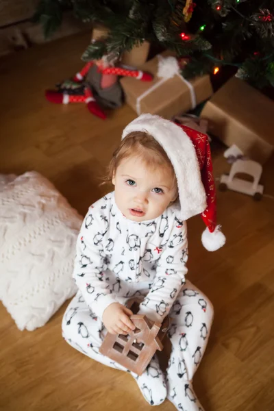 Menina bonito em pijama e chapéu de Natal — Fotografia de Stock