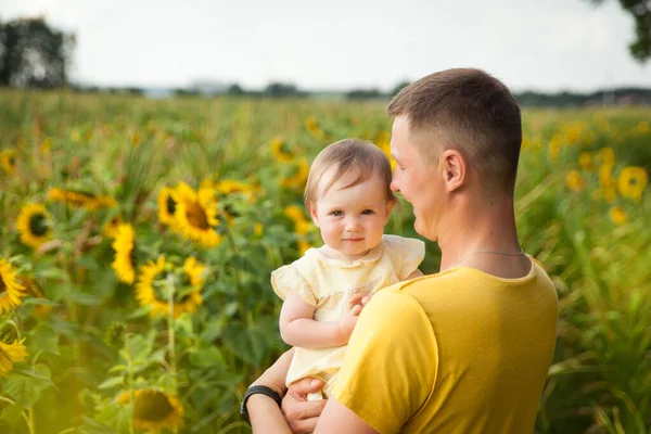 Cute Baby Girl Żółtej Sukience Jej Ojciec Zabawy Słonecznikowym Polu — Zdjęcie stockowe