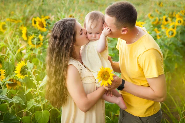 Cute Baby Girl Żółtej Sukience Rodzicami Zabawy Słonecznikowym Polu Letnim — Zdjęcie stockowe