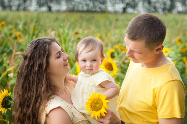 Cute Baby Girl Żółtej Sukience Rodzicami Zabawy Słonecznikowym Polu Letnim — Zdjęcie stockowe