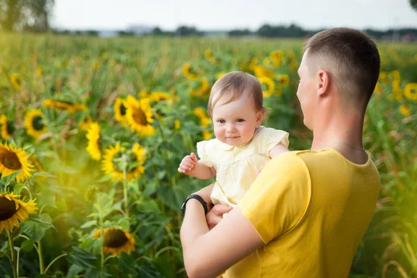 Cute Baby Girl Żółtej Sukience Jej Ojciec Zabawy Słonecznikowym Polu — Zdjęcie stockowe