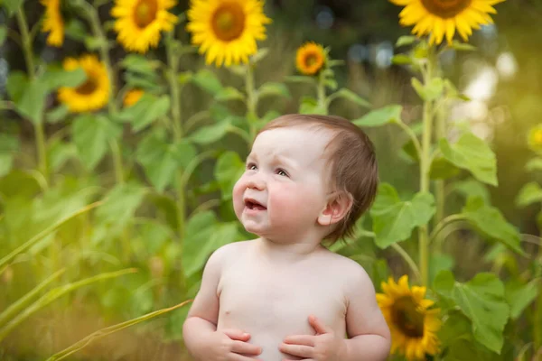可愛い赤ちゃんの女の子はひまわりの夏のフィールドで楽しんで — ストック写真