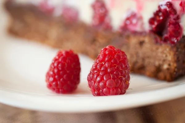 Raspberry close-up with cheesecake on background — Stock Photo, Image