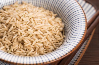 Kase içinde çiğ kahverengi pirinç.