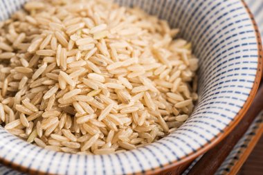 Kase içinde çiğ kahverengi pirinç.