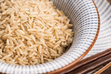 Kase içinde çiğ kahverengi pirinç.