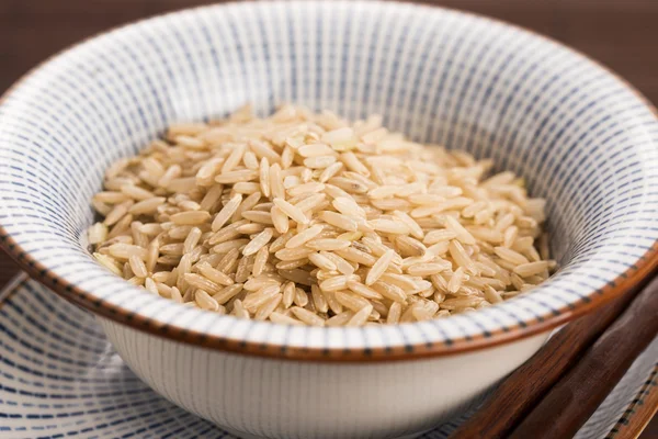 Kase içinde çiğ kahverengi pirinç.