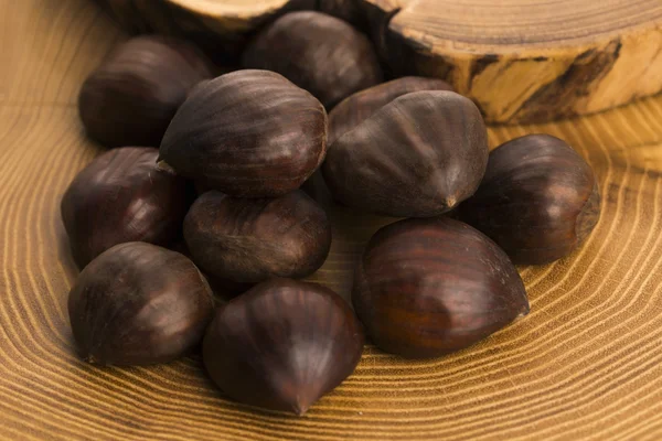 Castañas sobre fondo de madera — Foto de Stock