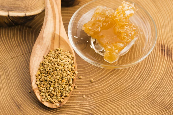 Färska bipollen i sked med honeycomb — Stockfoto