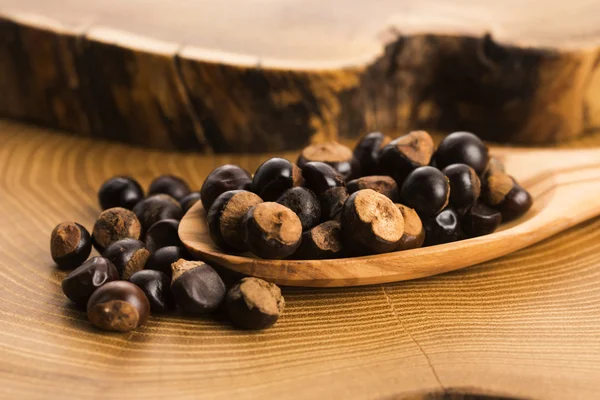 Guarana seeds on wooden spoon — Stock Photo, Image