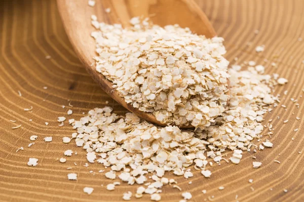 Fiocchi di quinoa su cucchiaio di legno — Foto Stock