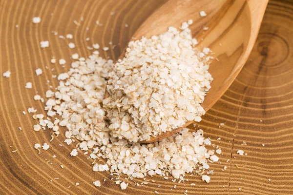 Fiocchi di quinoa su cucchiaio di legno — Foto Stock