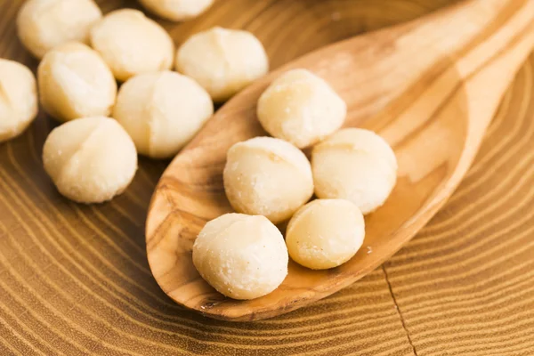 Nueces de macadamia asadas sobre fondo rústico de madera — Foto de Stock