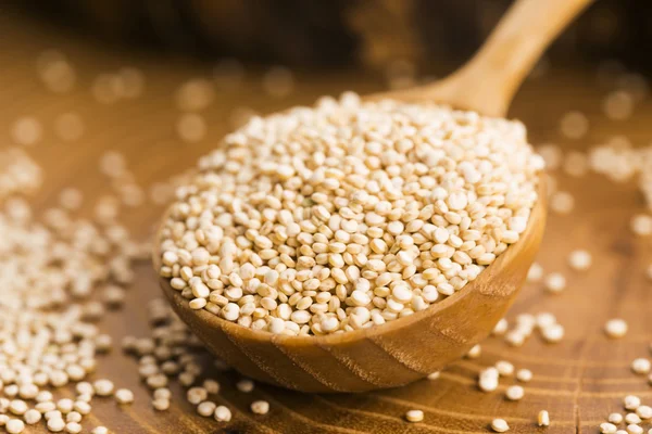 White quinoa seeds on a wooden background — Stock Photo, Image