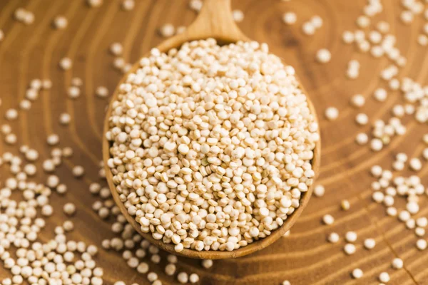 White quinoa seeds on a wooden background — Stock Photo, Image