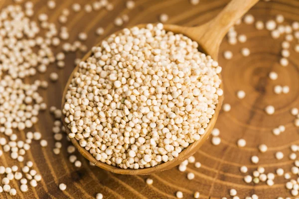 Sementes de quinoa branca em um fundo de madeira — Fotografia de Stock