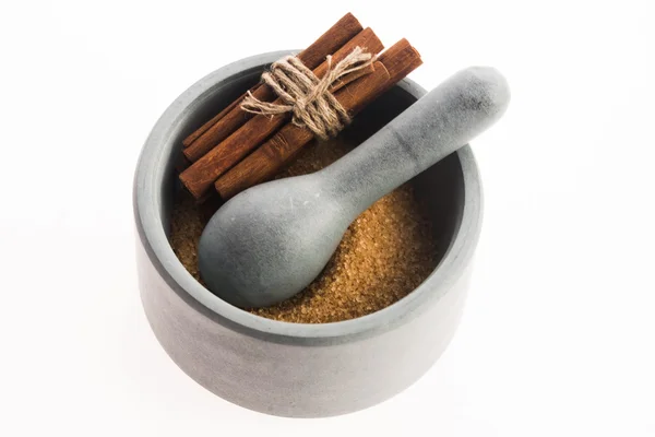 Cinnamon sticks with pure cane brown sugar in mortar — Stock Photo, Image