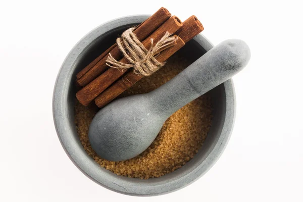 Cinnamon sticks with pure cane brown sugar in mortar — Stock Photo, Image