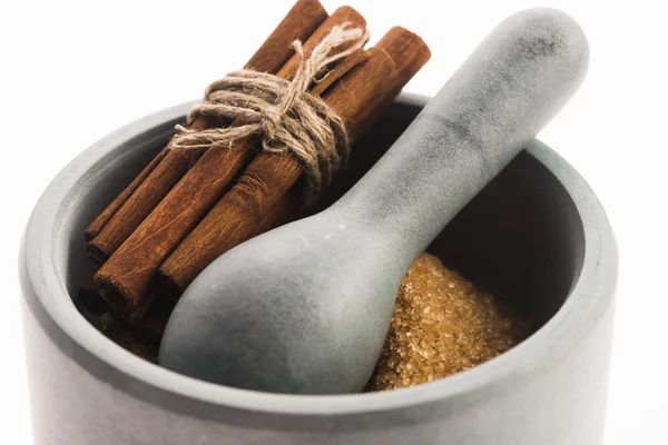 Cinnamon sticks with pure cane brown sugar in mortar — Stock Photo, Image