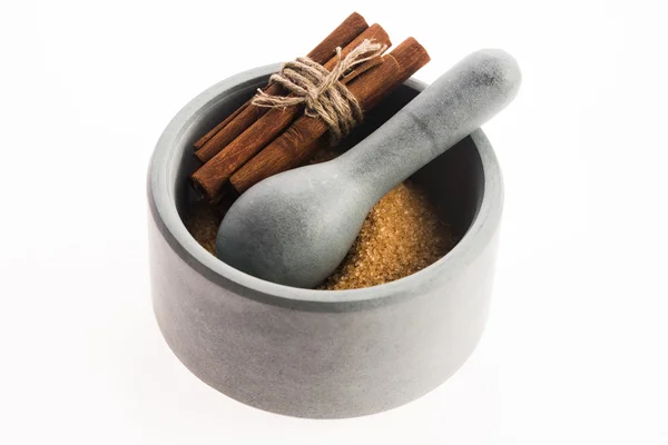 Cinnamon sticks with pure cane brown sugar in mortar — Stock Photo, Image