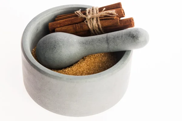 Cinnamon sticks with pure cane brown sugar in mortar — Stock Photo, Image