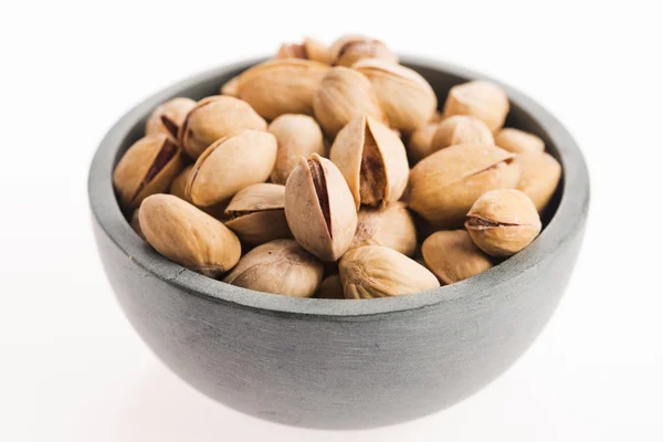 Bowl of pistachios on white background — Stock Photo, Image