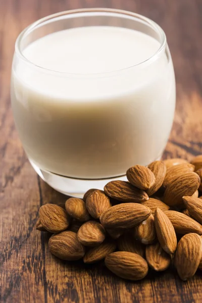 Almond milk with almond on a wooden table — Stock Photo, Image