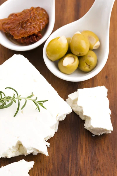 Queijo feta com azeitonas, tomates secos ao sol e ervas frescas — Fotografia de Stock