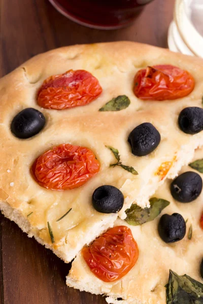 Focaccia con aceitunas negras, tomates y albahaca —  Fotos de Stock