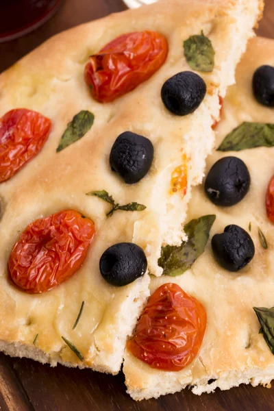 Focaccia con aceitunas negras, tomates y albahaca —  Fotos de Stock