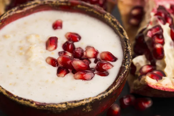 Dish of banana millet breakfast pudding with pomegranate — Stock Photo, Image