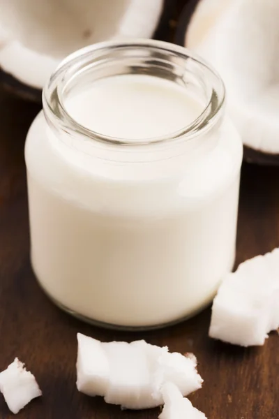 Leche de coco en un vaso sobre fondo de madera oscura —  Fotos de Stock