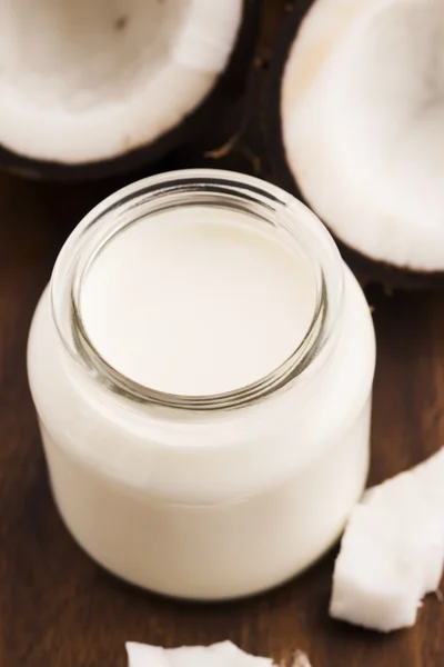 Kokosmilch im Glas auf dunklem Holzgrund — Stockfoto