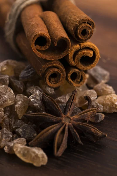 Cinnamon sticks with pure cane brown sugar on wood background — Stock Photo, Image