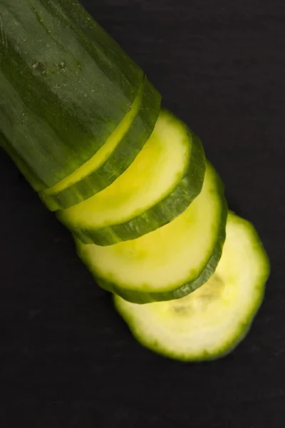 Cucumber slices on on black plate — Stock Photo, Image