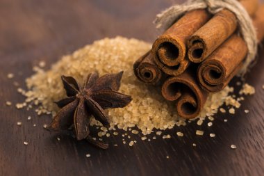 Ahşap arka plan üzerinde kahverengi şeker saf kamışı ile tarçın sopa