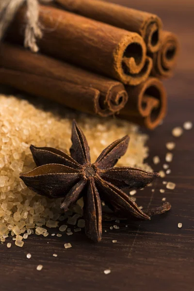 Cinnamon sticks with pure cane brown sugar on wood background — Stock Photo, Image