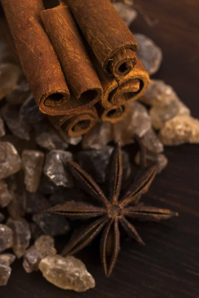 Cinnamon sticks with pure cane brown sugar on wood background — Stock Photo, Image