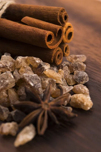 Cinnamon sticks with pure cane brown sugar on wood background — Stock Photo, Image