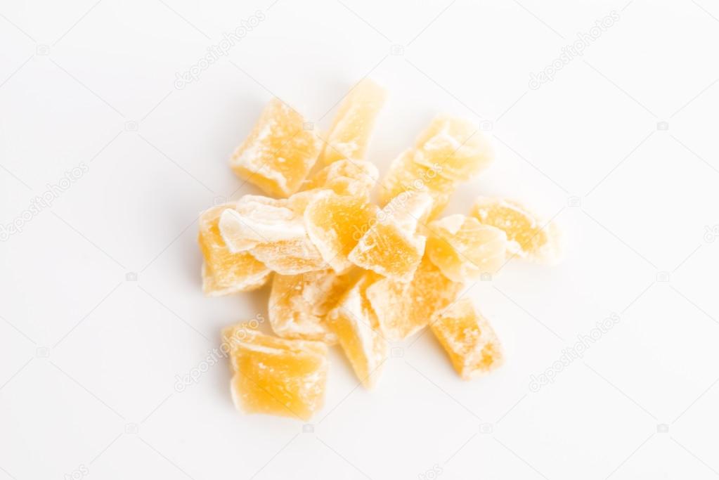 Caramelized ginger candy pieces isolated on white background