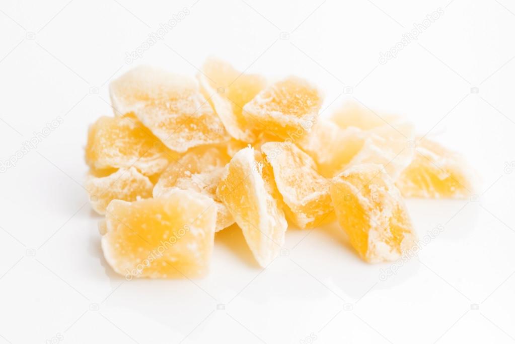 Caramelized ginger candy pieces isolated on white background