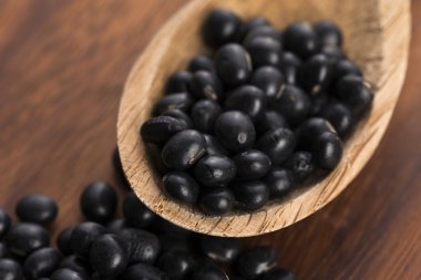 Bir sürü ahşap arka plan üzerinde siyah soya fasulyesi