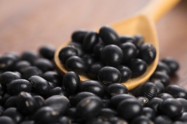 Bir sürü ahşap arka plan üzerinde siyah soya fasulyesi