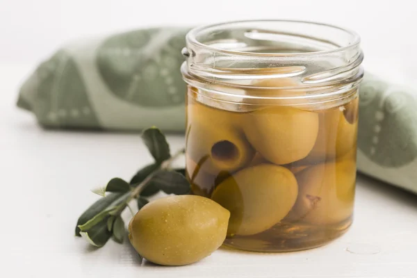 Pickled olives and olive tree branch — Stock Photo, Image